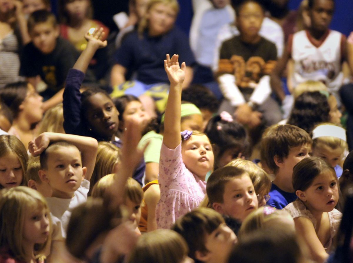 Second-grader Jordan Guercio raises her hand to ask a question of astronaut Kenneth Reightler Jr. and cosmonaut Yuri Usachev on Wednesday at Grant Elementary. (Jesse Tinsley / The Spokesman-Review)
