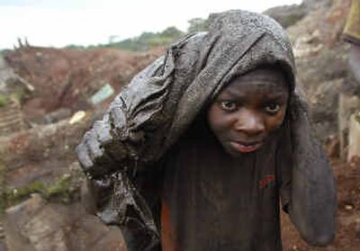 
A Jung man carries cobalt on his back in the Shinkolobwe cobalt mine outside the town of Likasi in Congo.
 (Associated Press / The Spokesman-Review)
