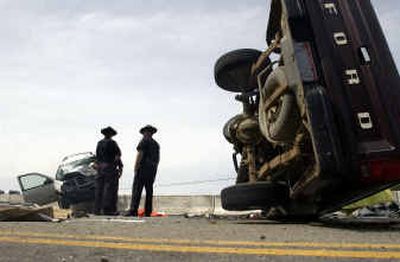 
Several Idaho State Police troopers examine the spot where two vehicles, a pickup and an SUV, collided head-on Tuesday, killing both drivers.
 (Jesse Tinsley/Spokesman-Review / The Spokesman-Review)