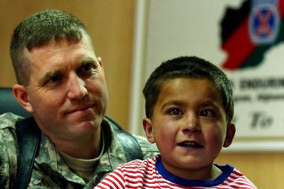 
Lt. Col. Drew Kosmowski, chief surgeon at a U.S. base in Afghanistan, poses with Omar Mohammed, an Afghan boy with a defective heart who will travel to Washington, D.C., for surgery. 
 (Associated Press / The Spokesman-Review)