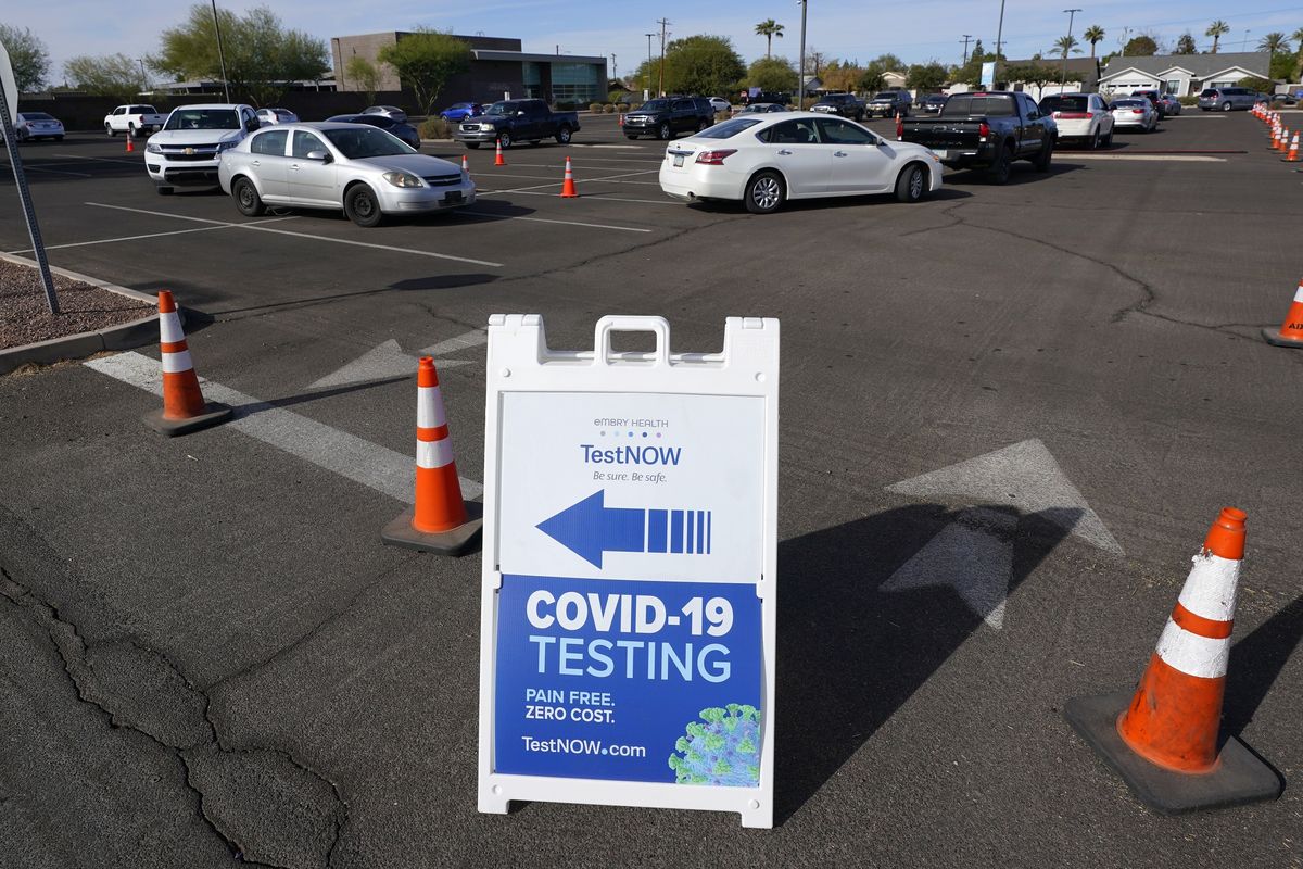 FILE - In this Dec. 8, 2020, file photo, vehicles line up as people wait for COVID-19 tests at a drive-thru testing center in Phoenix. Arizona on Wednesday, Jan. 6, 2021, reported a triple-digit number of additional COVID-19 deaths for the second day in a row along with more than 7,200 additional known cases and another record high of virus-related hospitalizations. The state has the worst coronavirus diagnosis rate in the country, with one person of every 119 people in the state being diagnosed in the past week.  (Ross D. Franklin)