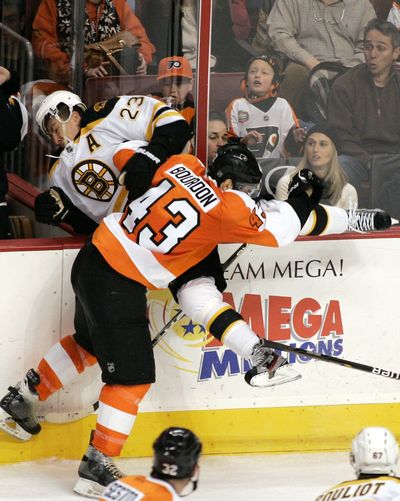 Boston’s Chris Kelly (23) is on the receiving end of a big hit from Philadelphia’s Marc-Andre Bourdon in a hard-earned Bruins’ win. (Associated Press)