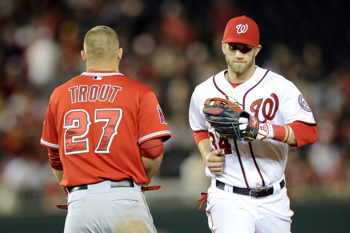 Bryce Harper and Mike Trout cross paths between innings of a game last season. (Associated Press)
