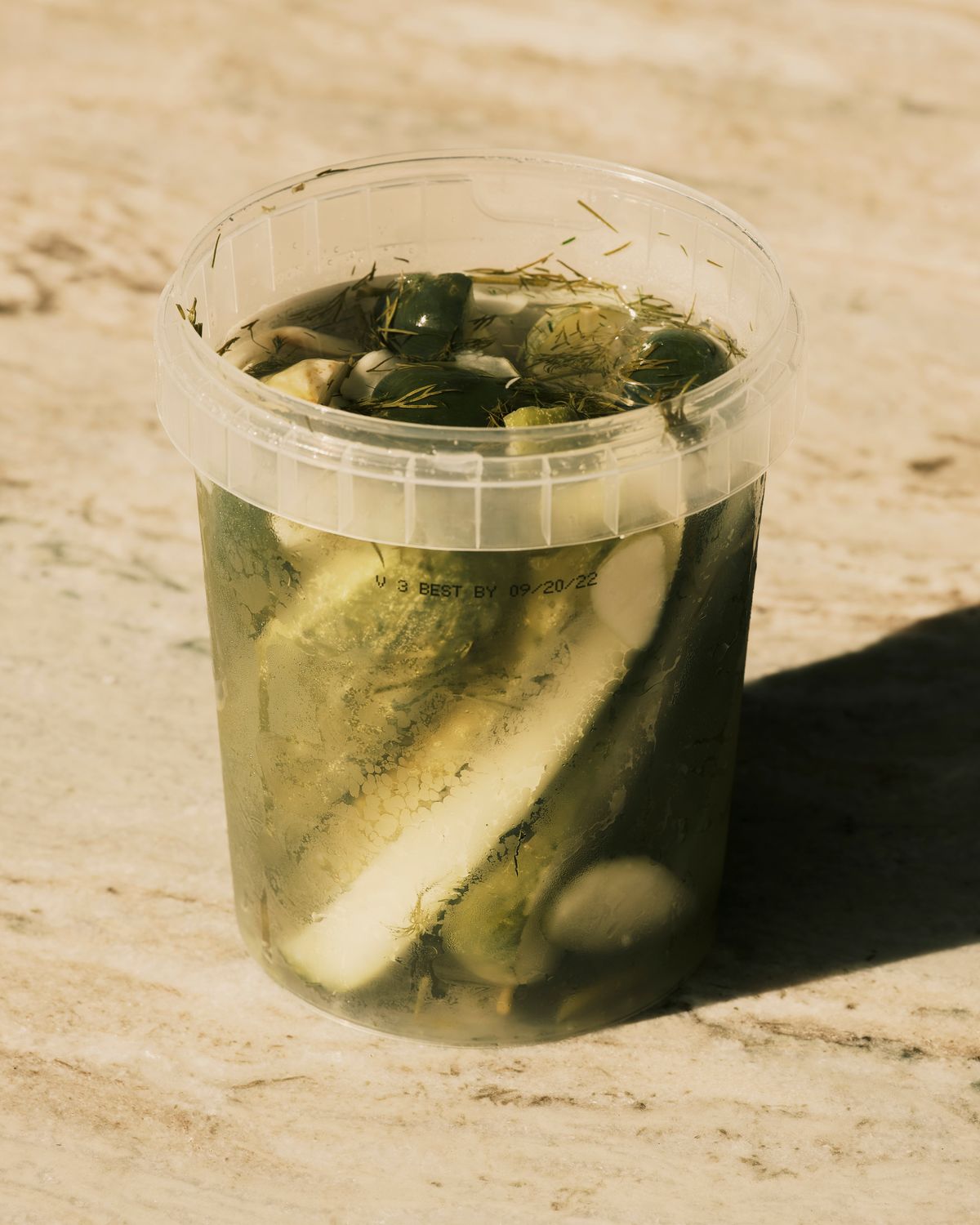 A jar of Grillo’s Pickles warm in the sunlight in Bradenton, Fla. on Saturday, July 30, 2022. Brands like Grillo’s Pickles have harnessed the cravings Americans have for pickles by teaming up with Utz and Ithaca Hummus to create new products.  (Zack Wittman/The New York Times)