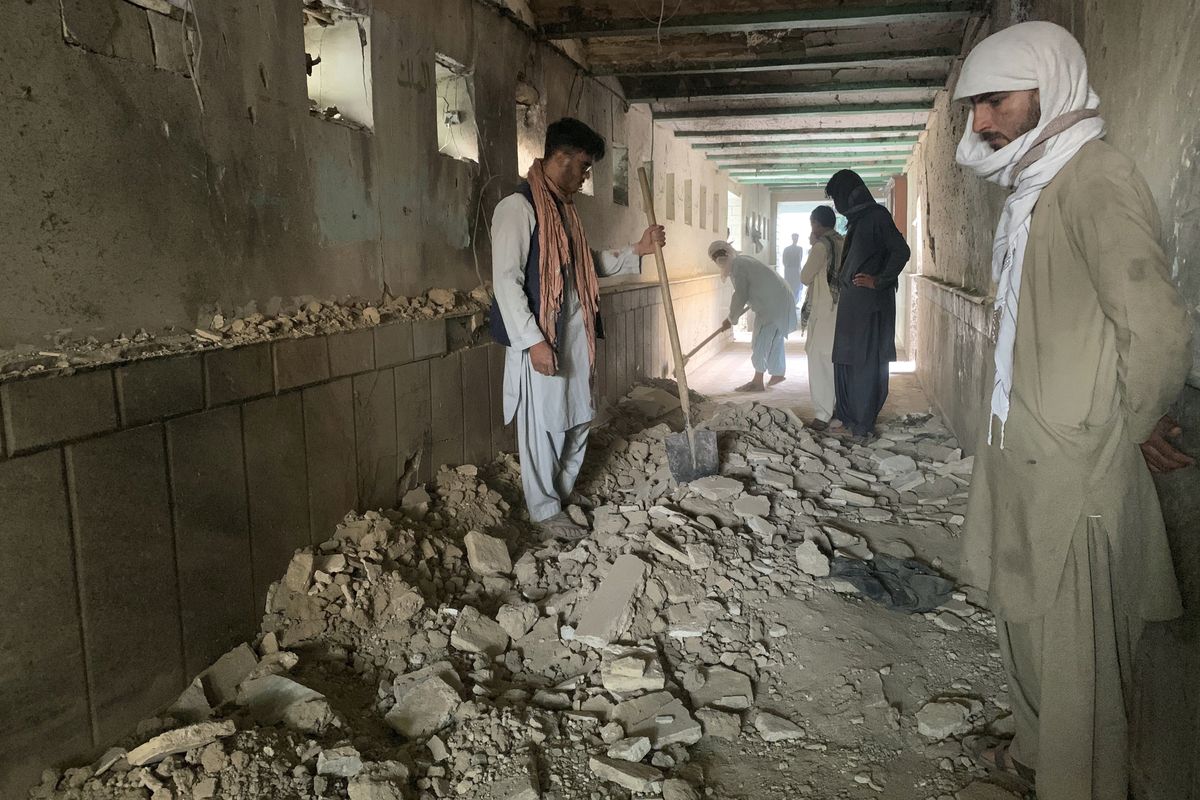 People inspect the inside of a mosque following a suicide bombers attack in the city of Kandahar, southwest Afghanistan, Friday, Oct. 15, 2021. Suicide bombers attacked a Shiite mosque in southern Afghanistan that was packed with worshippers attending Friday prayers, killing several people and wounding others, according to a hospital official and a witness.  (Sidiqullah Khan)